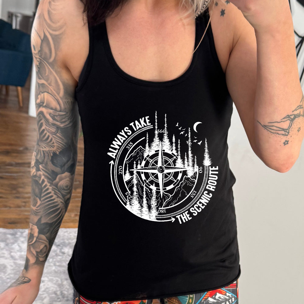 Black colored flowy tank with a compass and forest graphic on it that says "Always Take The Scenic Route" 