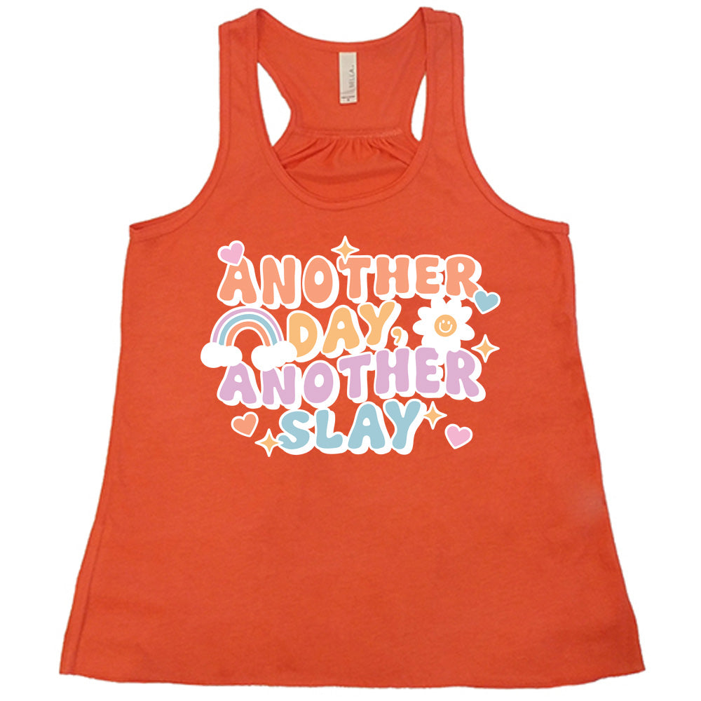 coral racerback flowy tank with the words "another day, another slay" on it, with little graphics of stars, hearts, a sun, and a rainbow