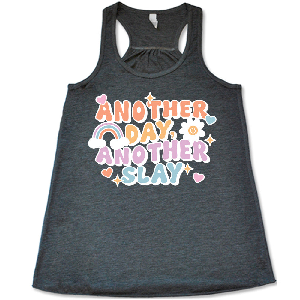 grey racerback flowy tank with the words "another day, another slay" on it, with little graphics of stars, hearts, a sun, and a rainbow