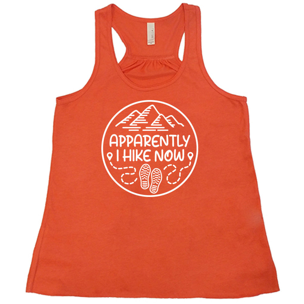 Coral colored flowy tank with a mountain and shoes graphic on it that says "Apparently I Hike Now" 