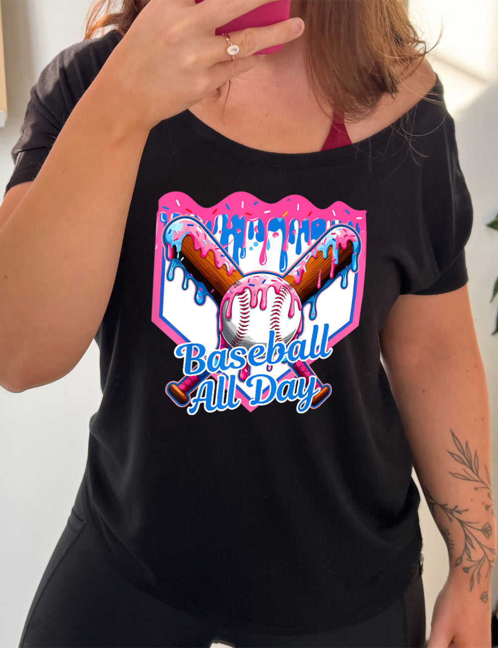 black slouchy tee with the graphic of a dripping baseball diamond, with the graphic of a dripping baseball with two dripping baseball bats behind it, and the words "baseball all day" on it