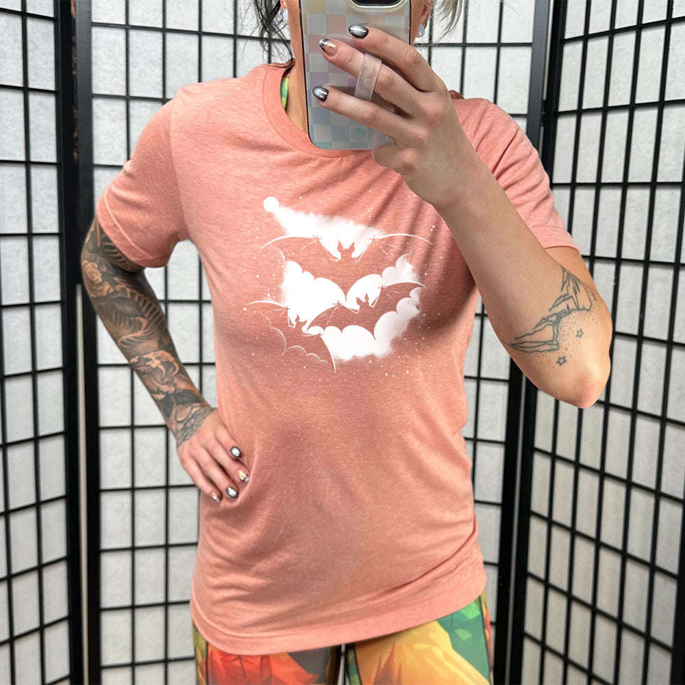 Model wearing sunset colored shirt with bats silhouette graphic on it