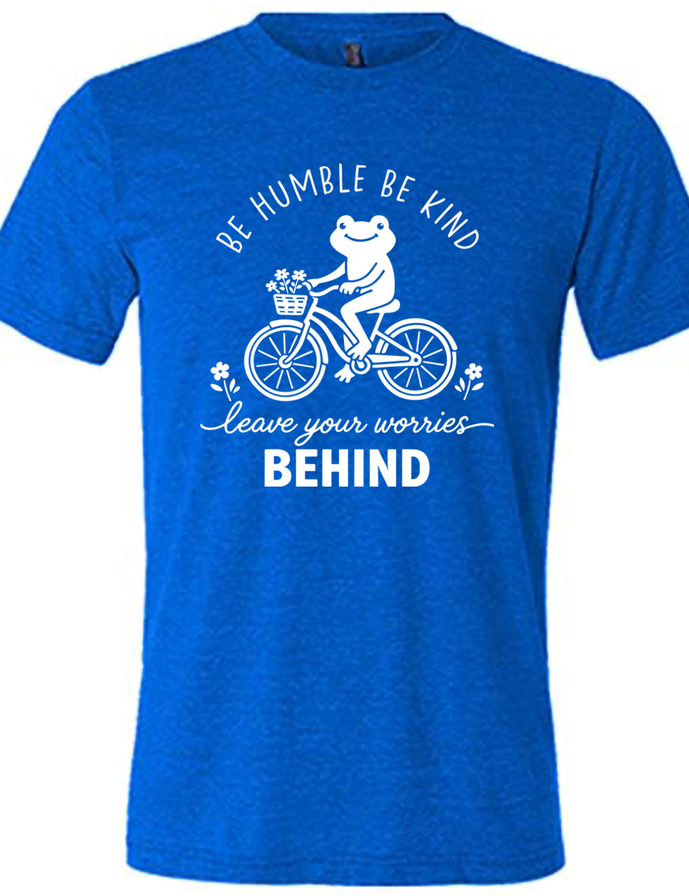 blue unisex tee with the graphic of a happy frog riding a bike that has a basket of flowers attached, with a flower in front and behind the bike, and the wording arching above and ending below saying "be humble be kind leave your worries BEHIND"