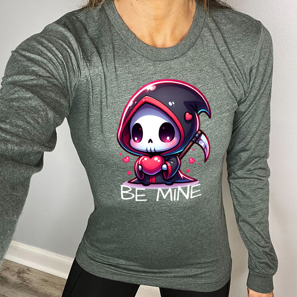 heather forest long sleeve with large graphics of a cartoony grim reaper holding a heart, with little hearts surrounding, and the words "be mine" on it
