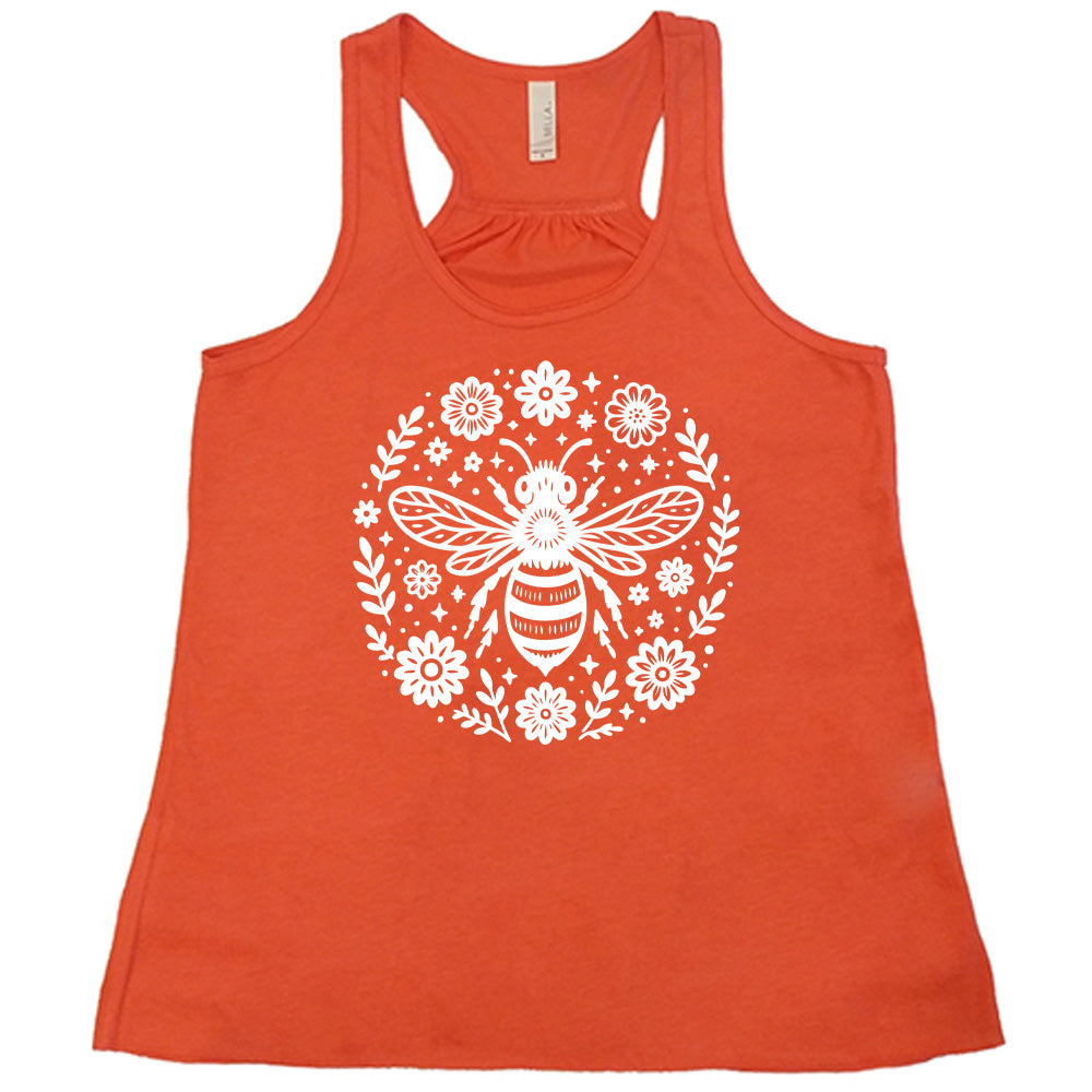 coral flowy racerback tank with the graphic of a boho circled design filled with flowers of varied size, some branches, some stars, and in the center a fancy bee