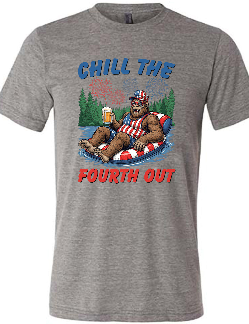 grey unisex tee with the graphic of a grinning Bigfoot holding a beer, wearing sunglasses and an American flag outfit, in an American flag tube, in the water, with a background of trees, with fireworks above, and the words saying "chill the fourth out" on it