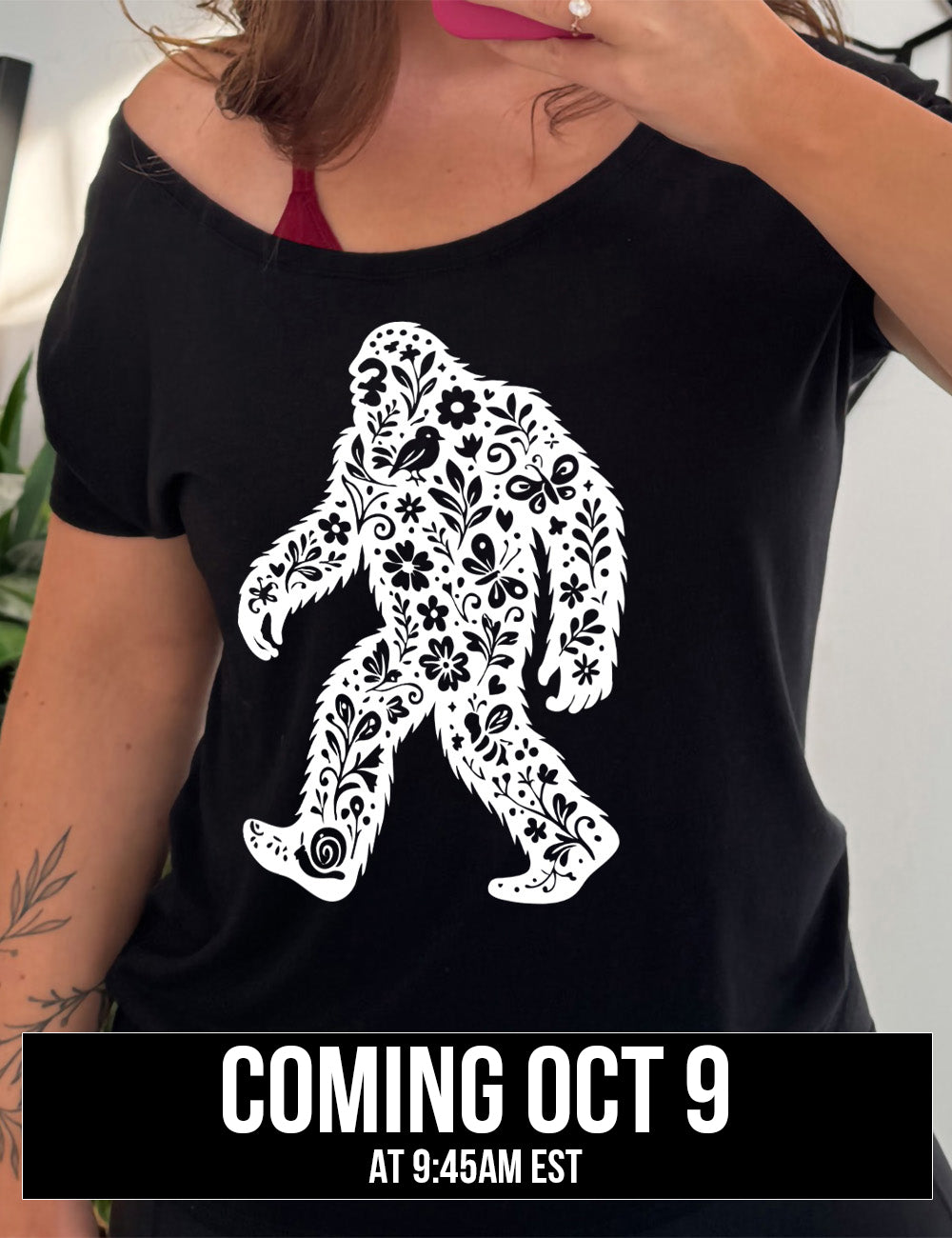 black slouchy tee with the graphic white cutout of bigfoot, which is overlayed with black flowers, plants, birds, bees, snails, and butterflies, coming October 9th