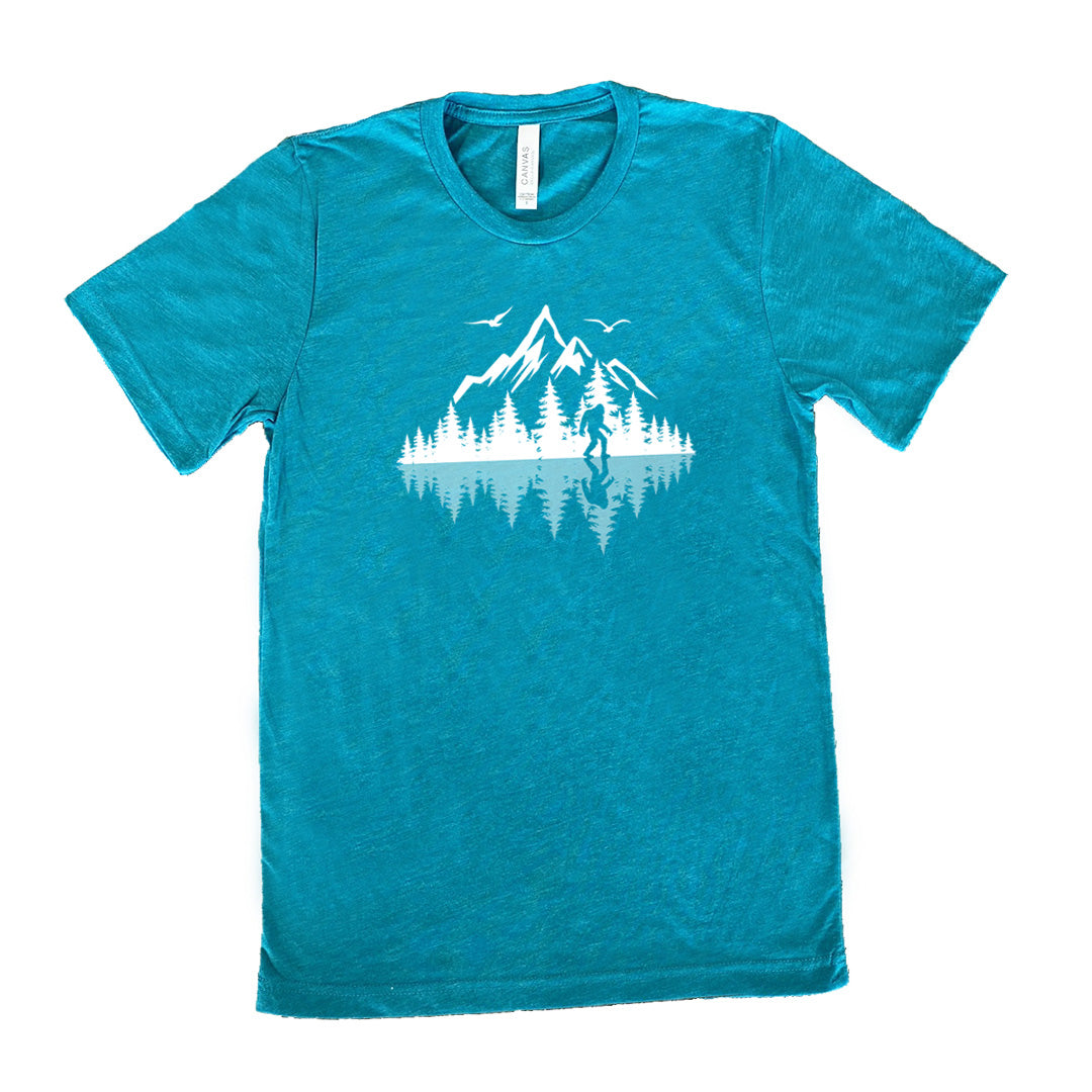 Teal colored shirt with bigfoot in nature with reflection graphic on it