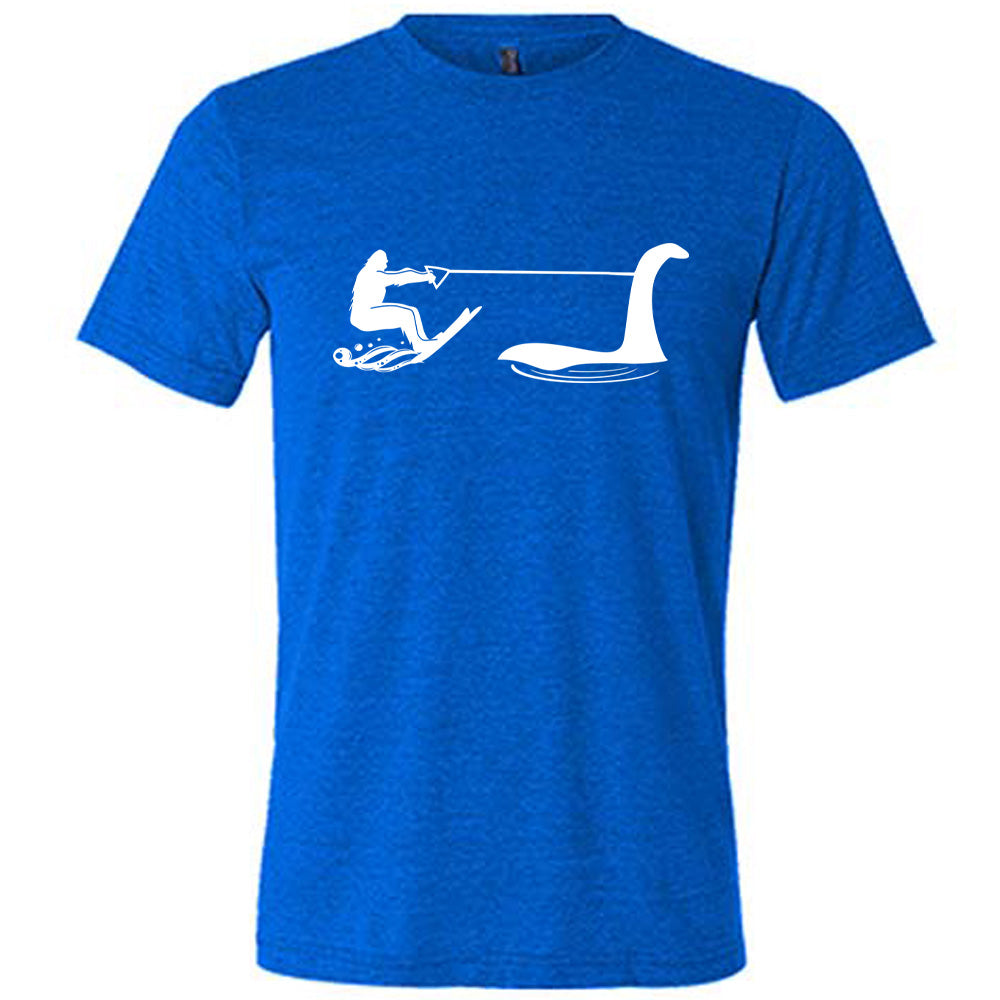 Blue colored shirt with bigfoot wakeboarding with Nessie graphic on it