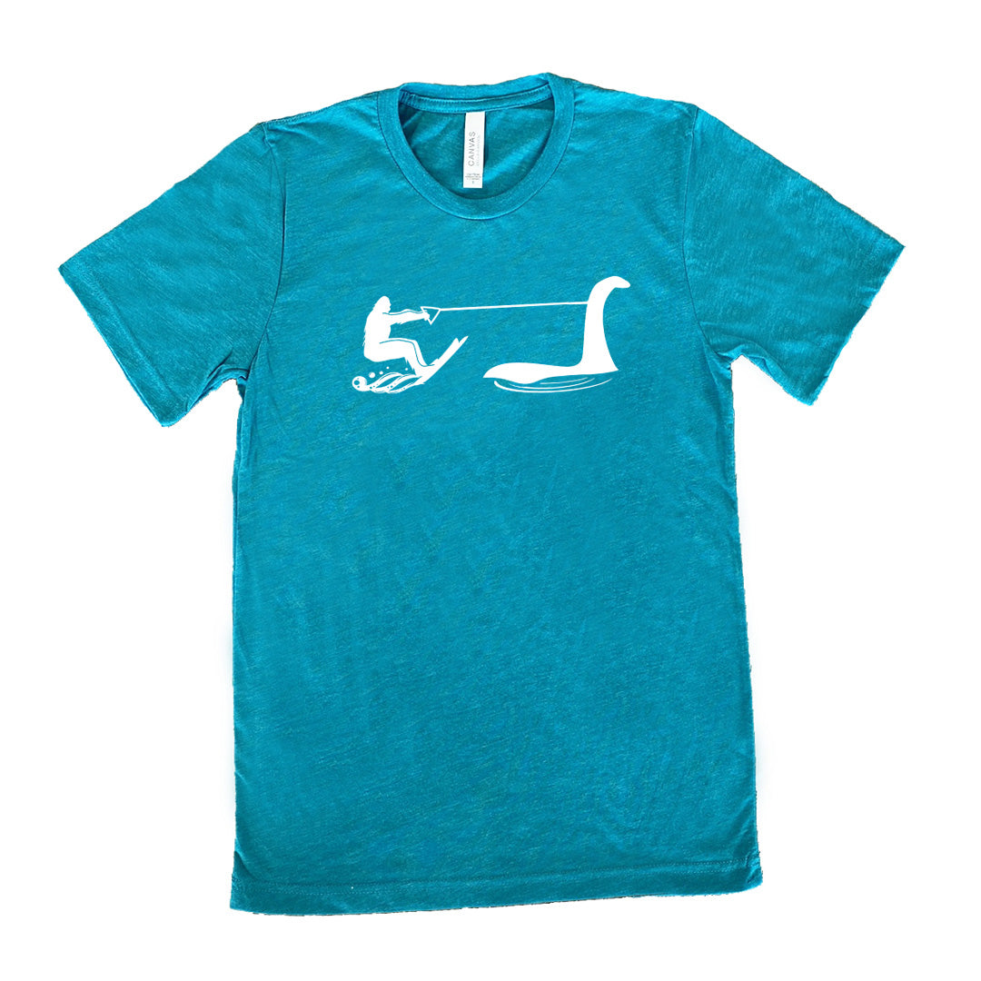 Teal colored shirt with bigfoot wakeboarding with Nessie graphic on it