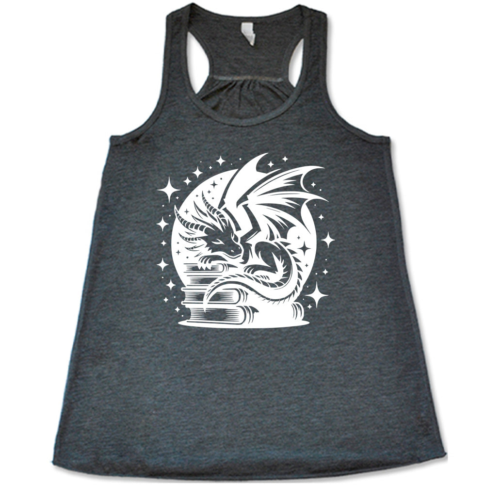 grey racerback tank with the graphic of a dragon resting on a stack of books, in front of a full moon, with many stars around