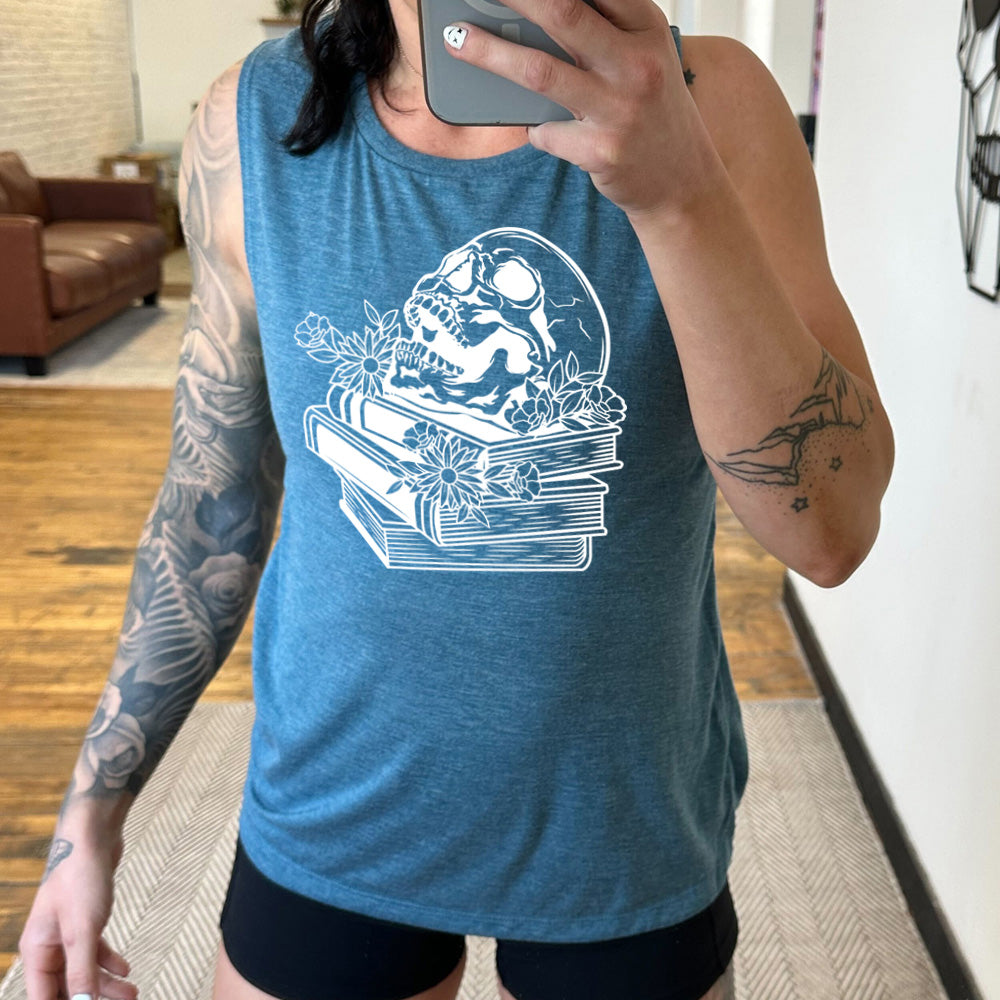 deep teal muscle tank with the graphic of an open-mouthed skull atop a stack of books, with flowers
