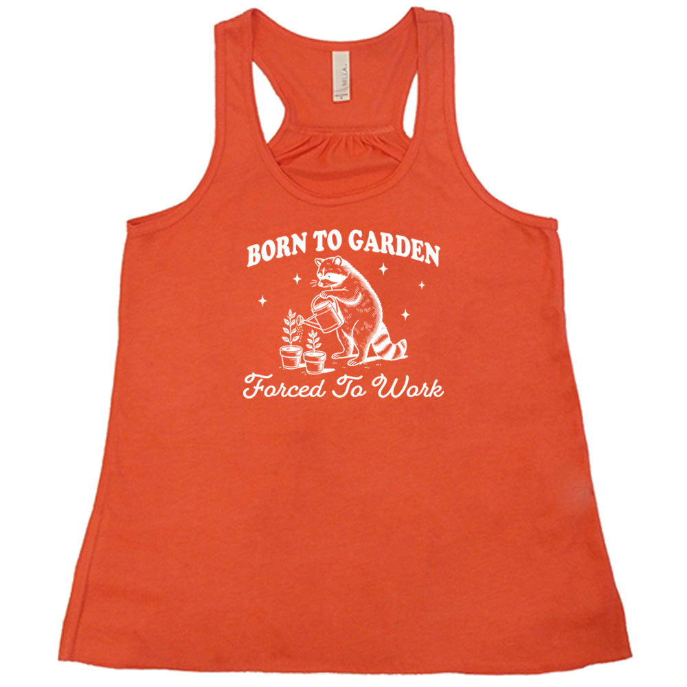 Coral colored flowy tank with a gardening raccoon graphic on it that says "Born to Garden, Forced to Work" 