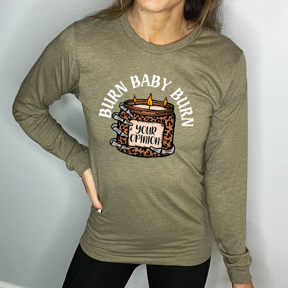 heather olive long sleeve tee with the text "Burn Baby Burn" on it, with the graphic of a skeletal hand hoping a leopard print candle, with three wicks alight, that has the words "your opinion" on it
