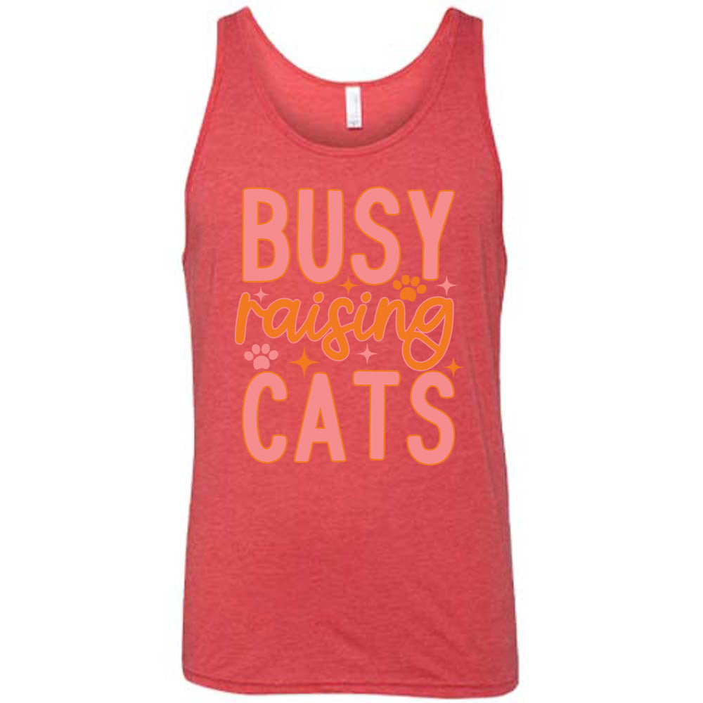 red unisex tank with the words "busy raising cats" on it, with graphics of a couple small paw prints and a number of little stars