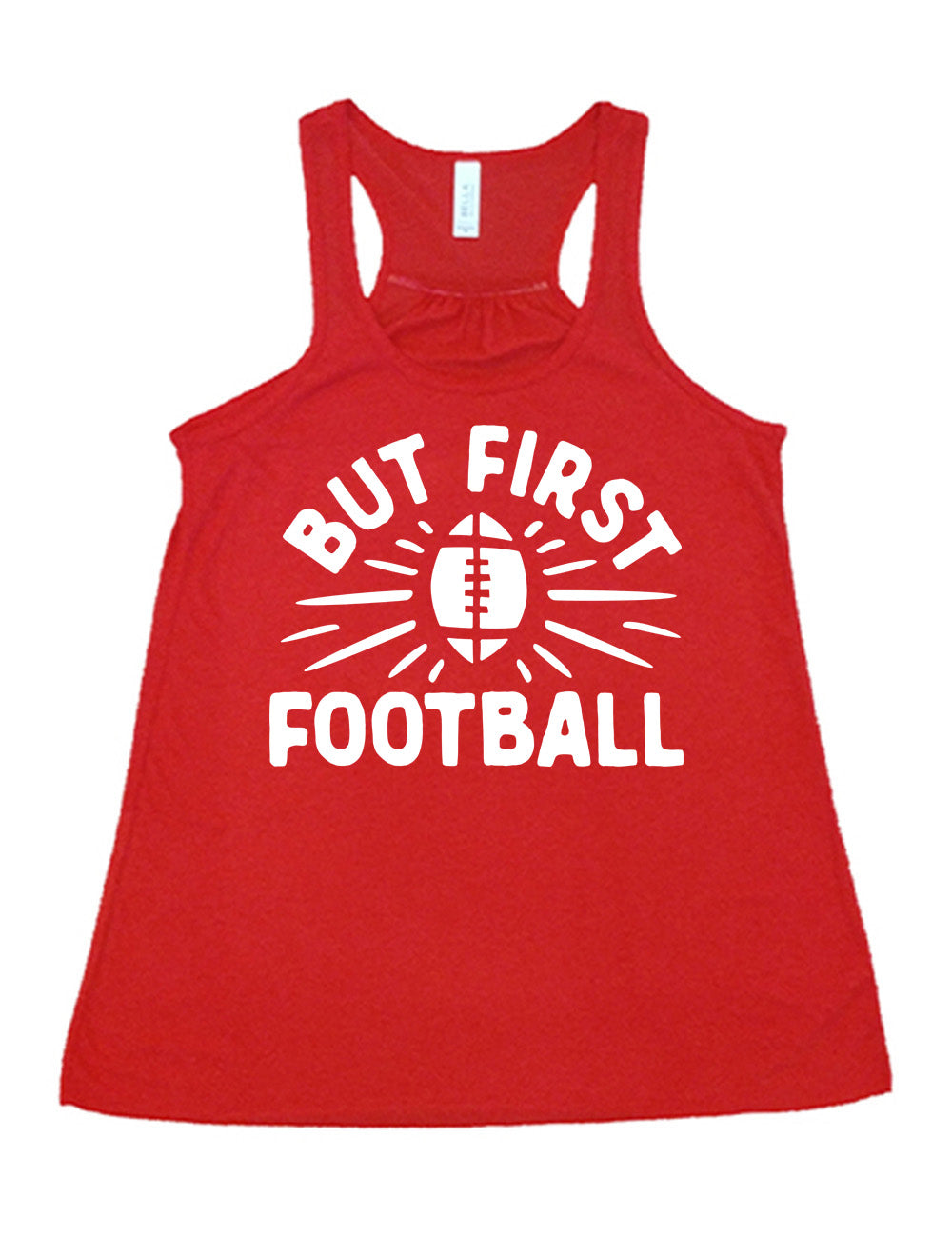 red flowy racerback tank with the words "but first football" in capital font, with "But first" arching over the graphic of a football, with rays beaming off of it