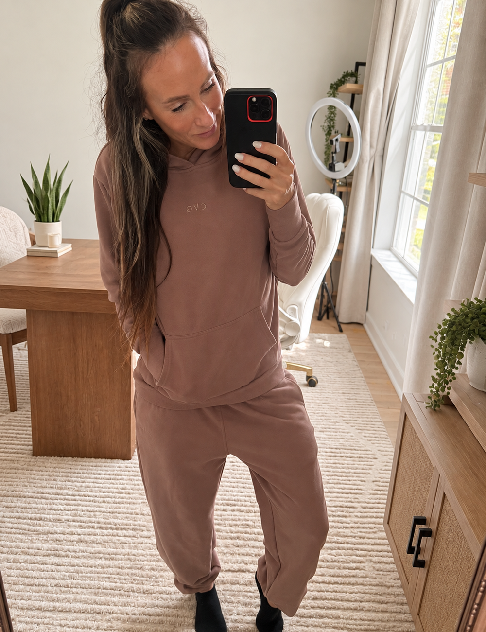 mirror selfie of a model wearing a brown sweatshirt and matching sweatpants