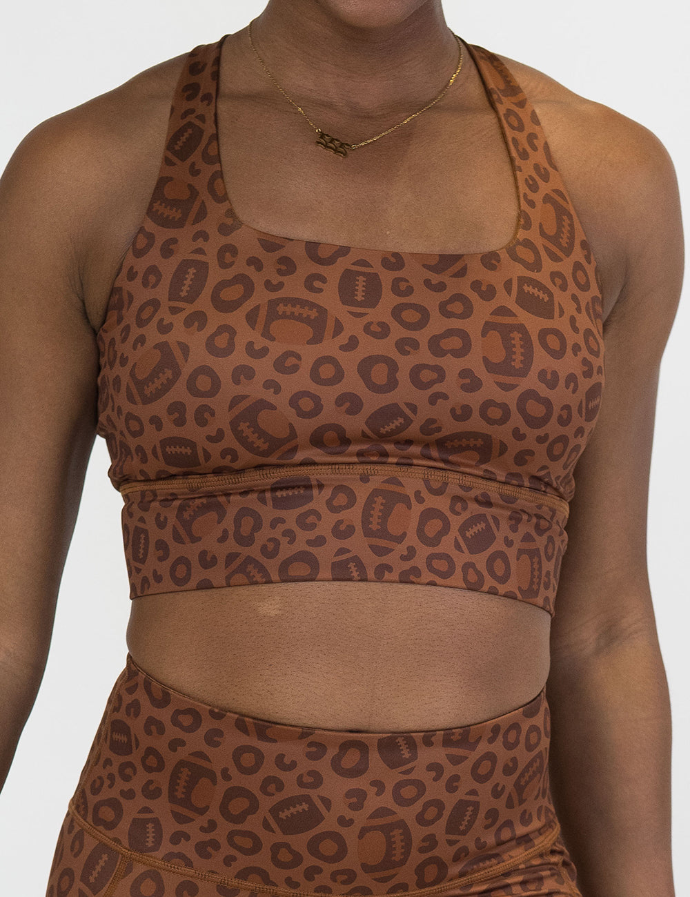 front of the football themed brown leopard print sports bra against a white background
