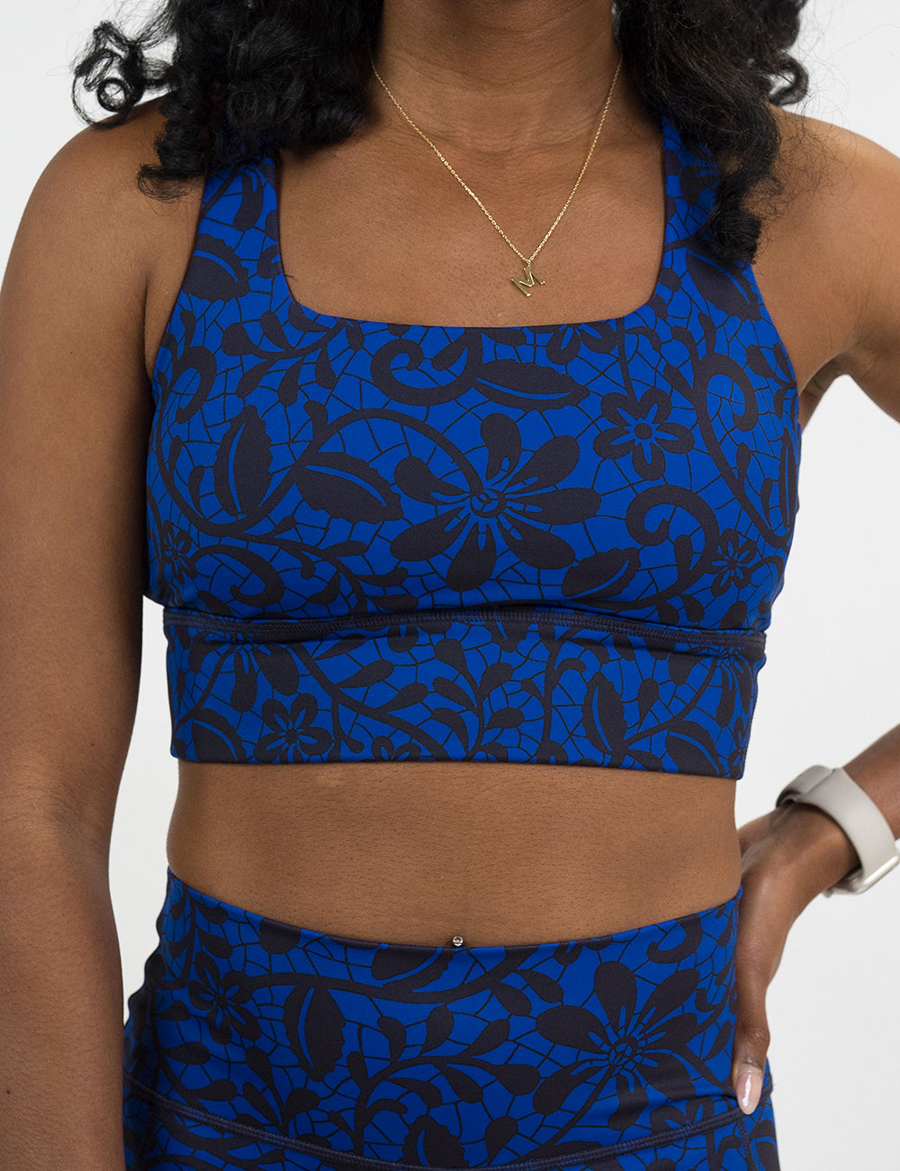 front of the black floral against a dark blue background longline bra against a white background
