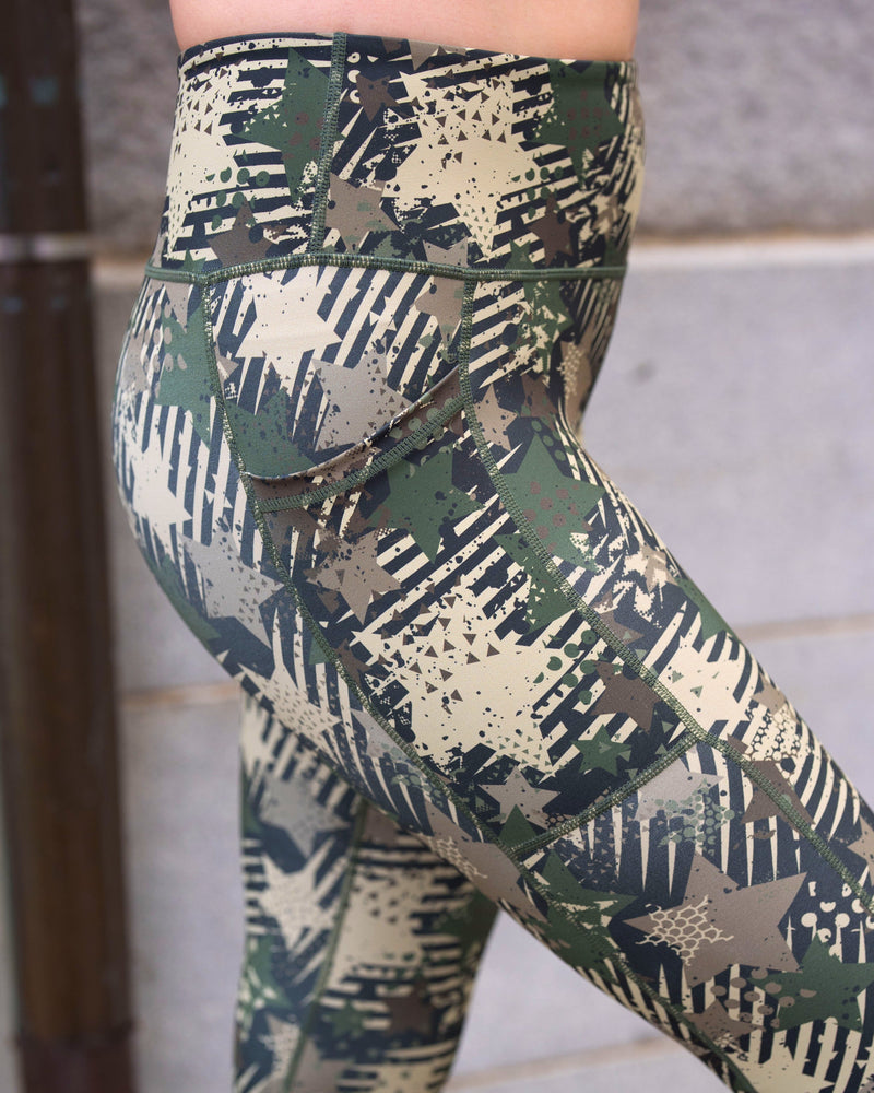 Close-up of a person wearing camouflage print leggings with a high waistband