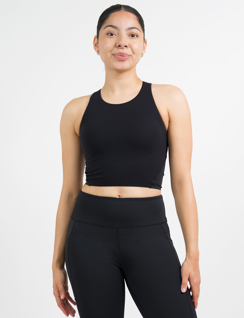 model wearing black racerback crop top and black leggings