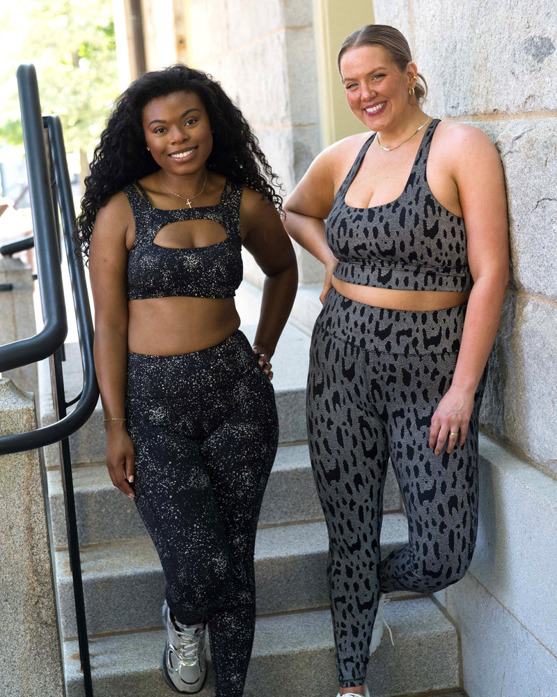 models wearing reflective leggings and sports bras with the camera flash on to show the reflective surface