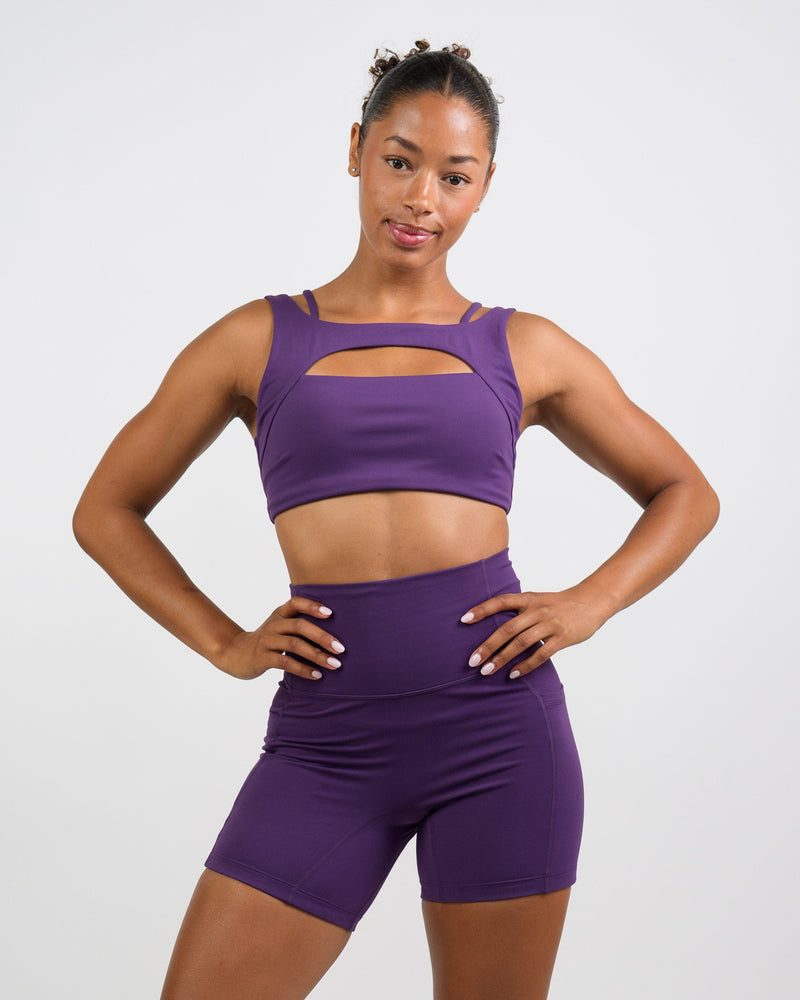 model wearing the solid purple shorts and sports bra