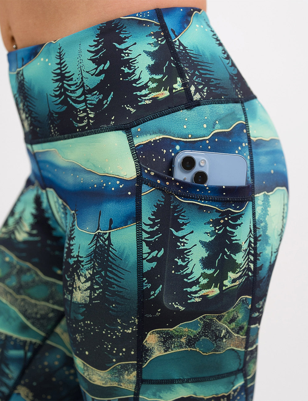 close up of the aurora forest pattern leggings with a phone in its pocket