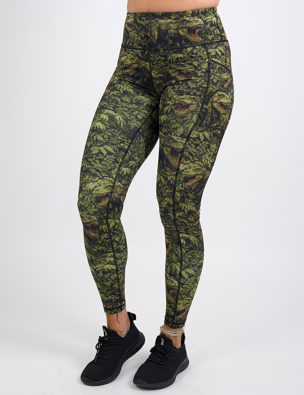 front of the full length t-rex in a forest leggings against a white background