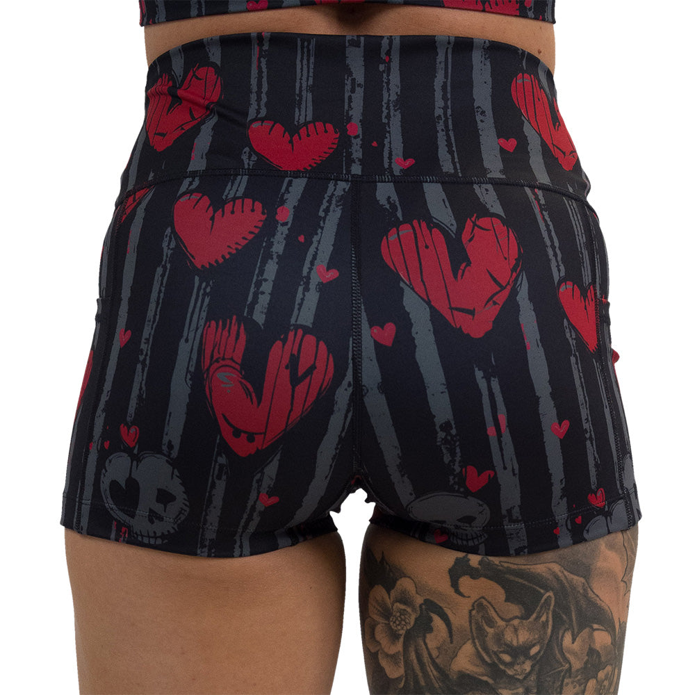 back of the 2.5 inch red heart and gray skulls against a black and grey striped background shorts against a white background