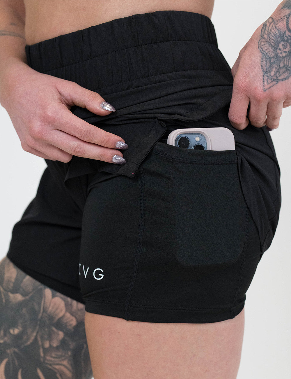 black day dream shorts rolled up to show the pocket holding a phone