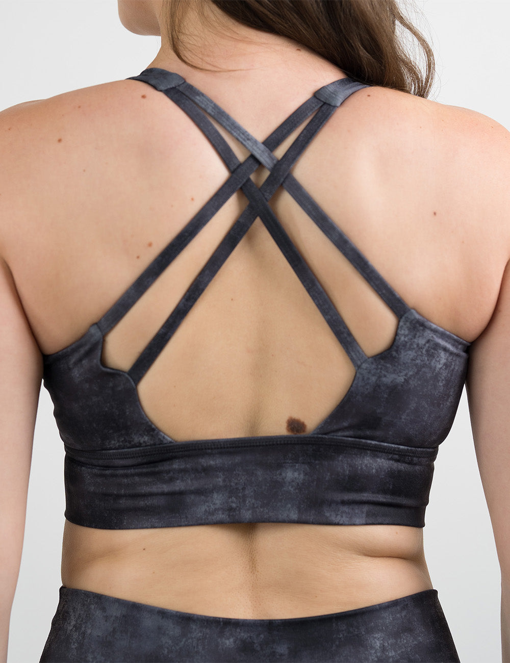 back of the black and grey grunge concrete pattern bra against a white background