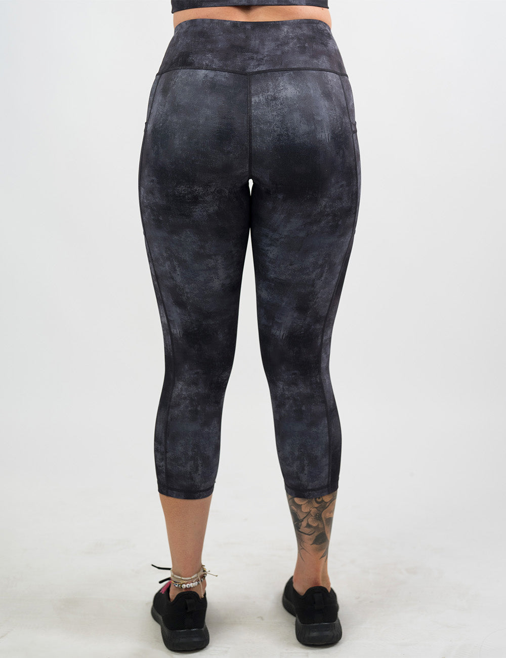 back of the black and grey grunge concrete pattern capri leggings against a white background