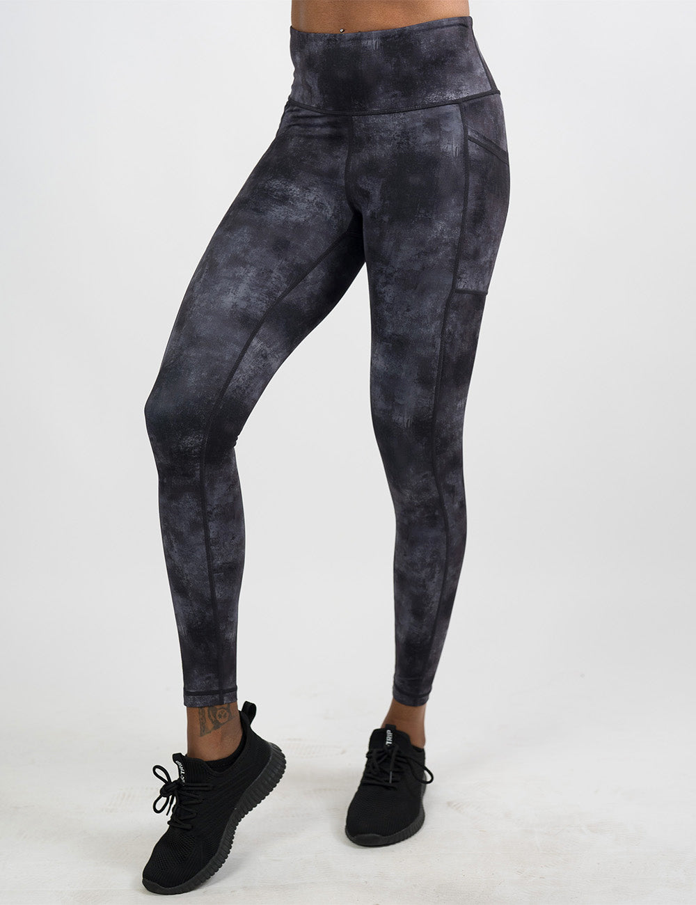 front of the full length black and grey grunge concrete pattern leggings against a white background