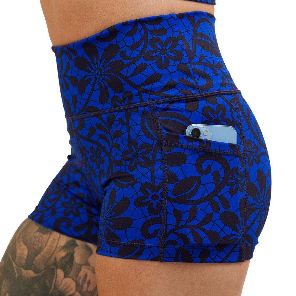 black floral against a dark blue background 2.5 inch shorts with a close up a phone in the pocket