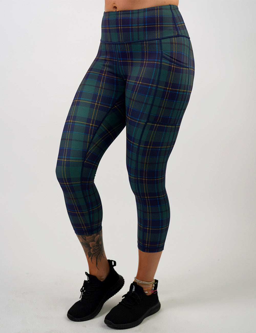 front of the blue, green, and yellow plaid capri leggings against a white background