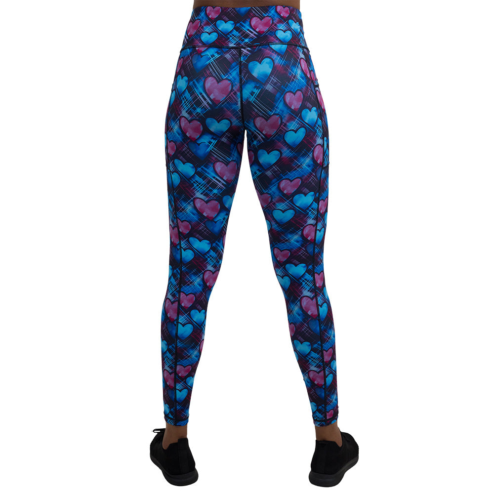 back of the blue and pink hearts pattern against a dark stitched background full lengths leggings against a white background