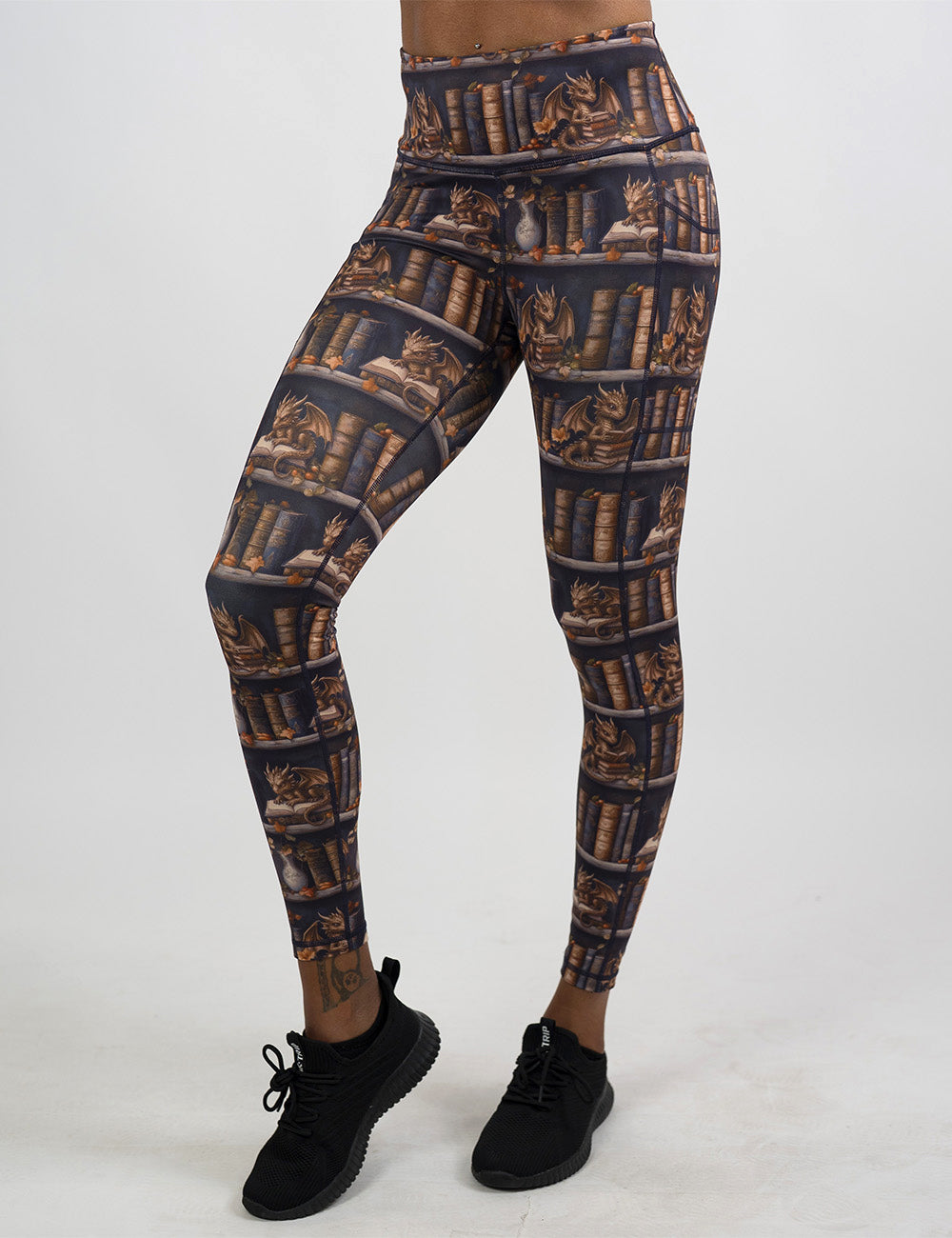 front of the full length gold dragons reading books leggings against a white background