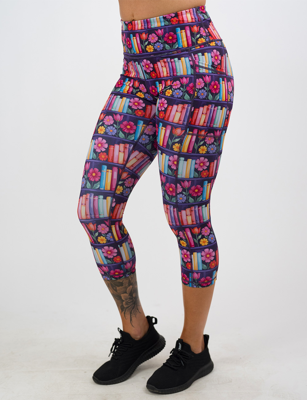 brightly colored books and flowers capri leggings facing the front against a white background