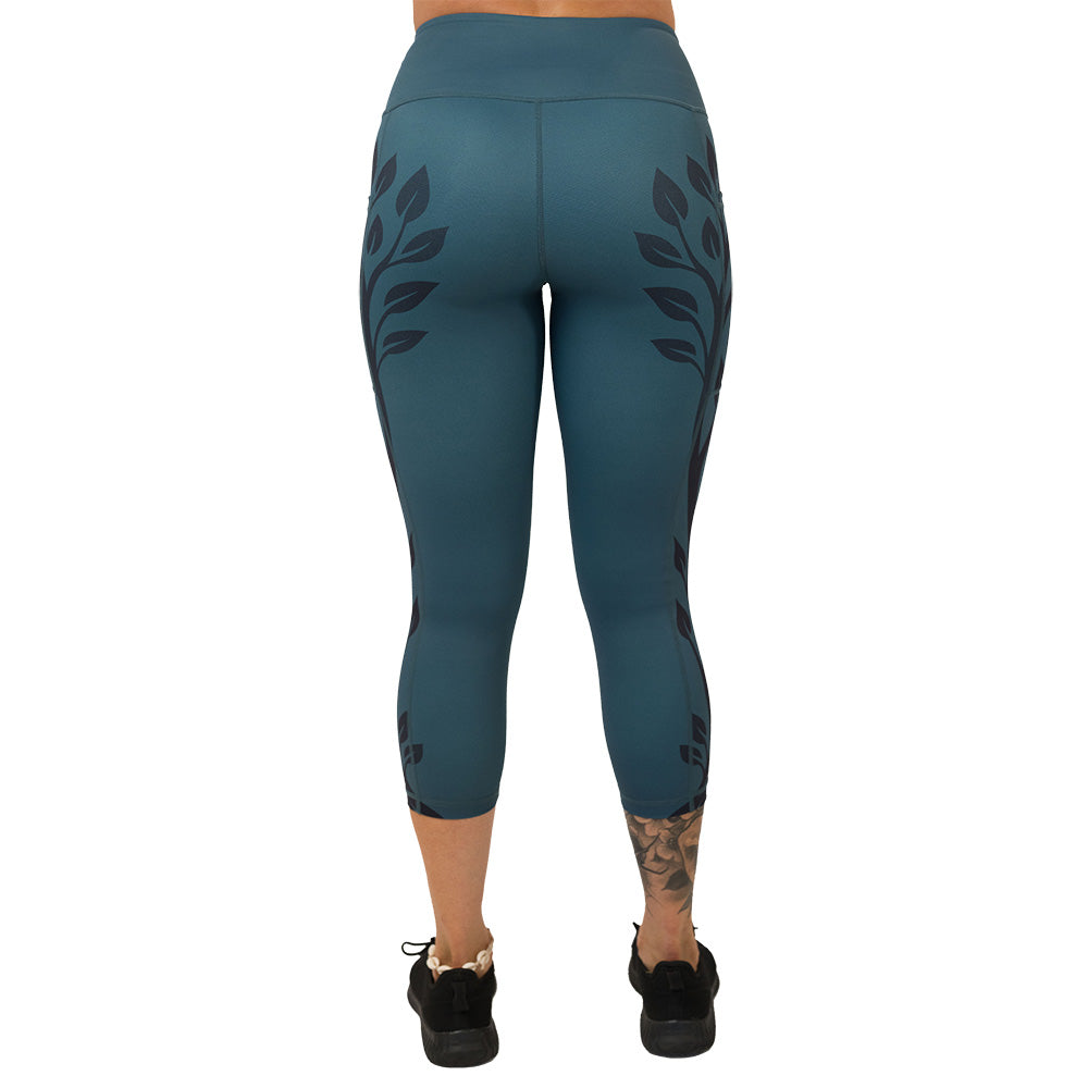 back of the Teal leggings with black leaf pattern on a white background