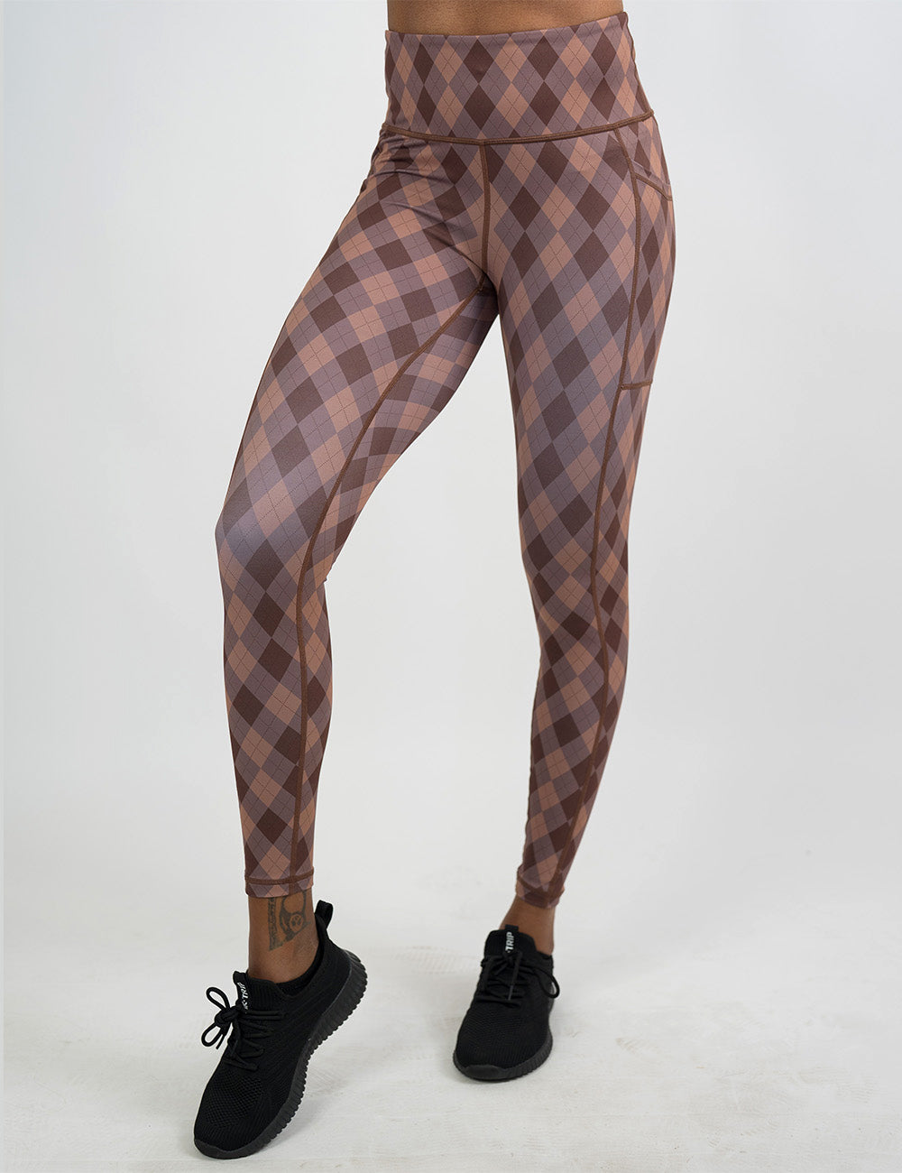 front of the grey, beige, and dark red plaid full length leggings against a white background