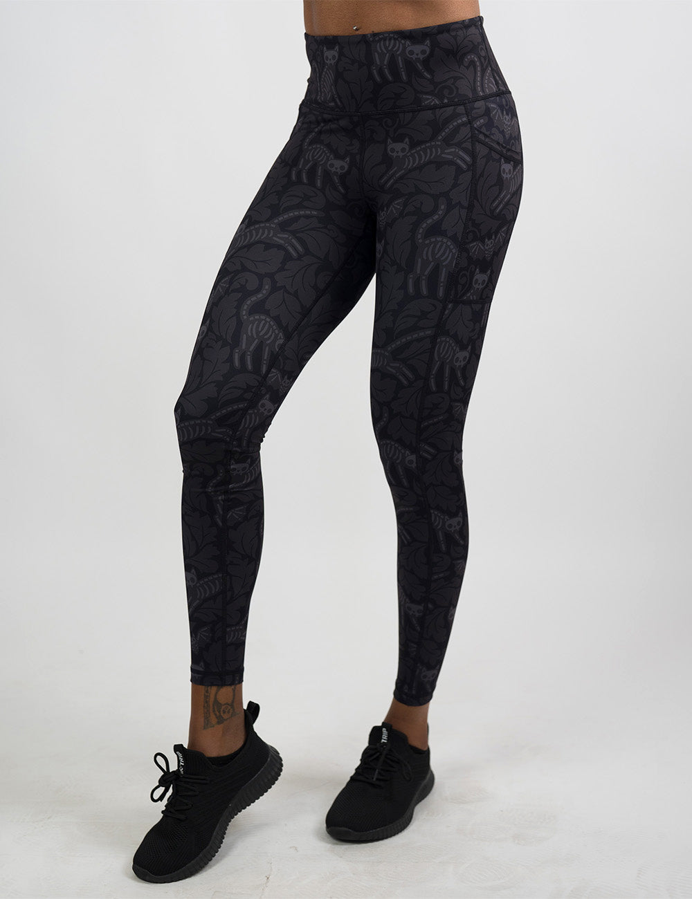 front of the black and grey bats and cats skeletons full length leggings against a white background