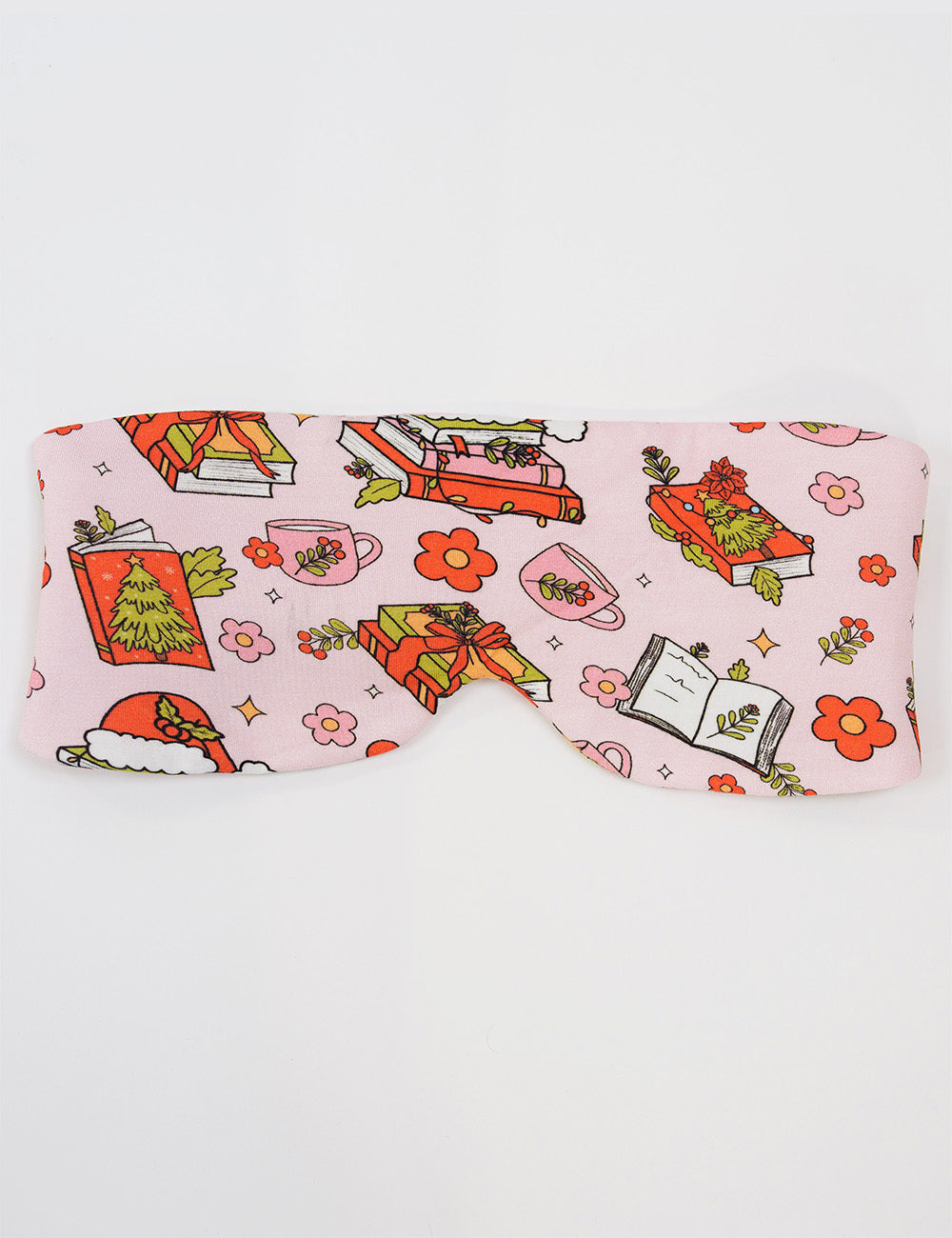 front of the Christmas books and flowers all over pink eye mask against a white background