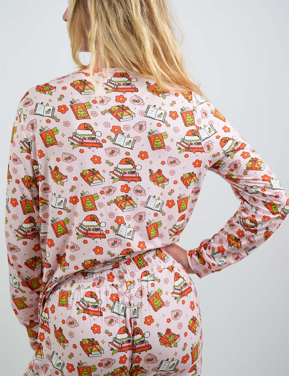back of the Christmas books and flowers all over pink pajama top against a white background