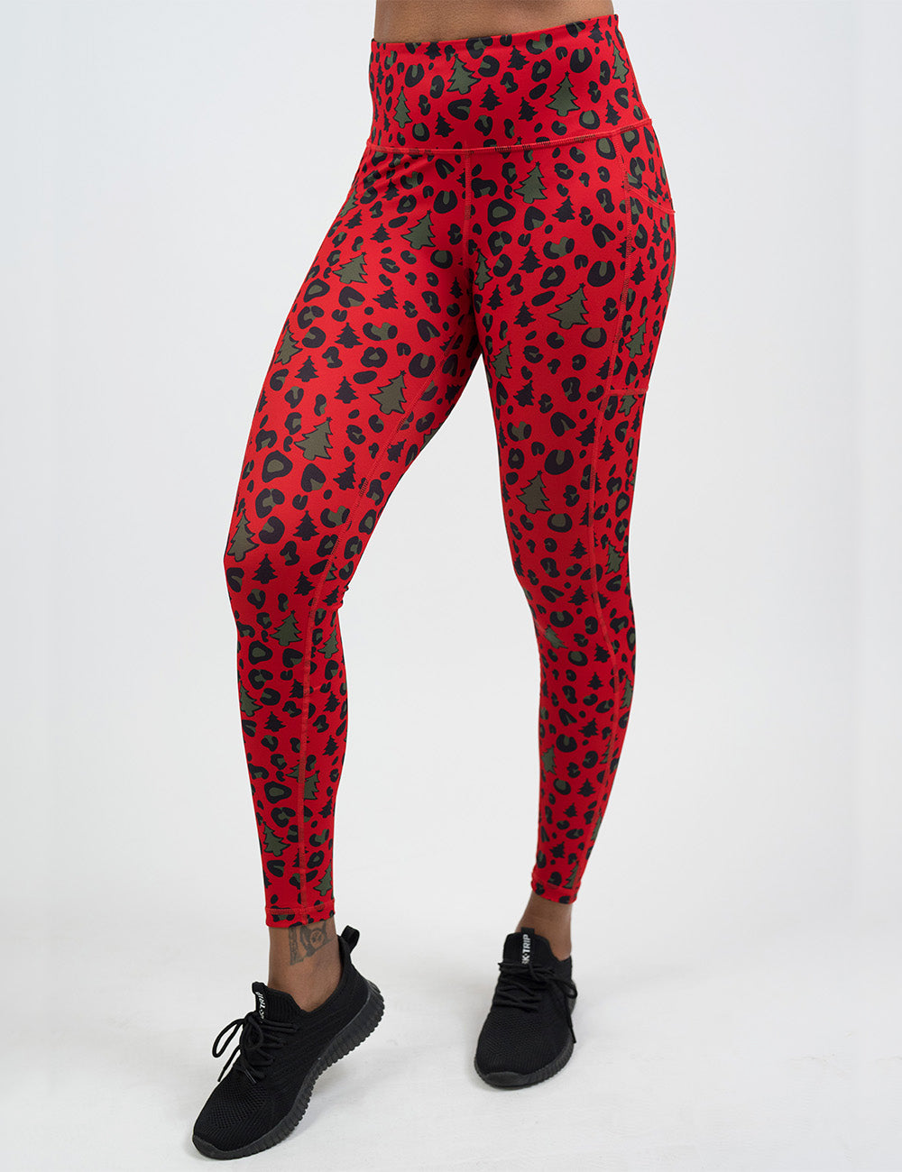 front of the red and brown Christmas trees and leopard print full length leggings against a white background
