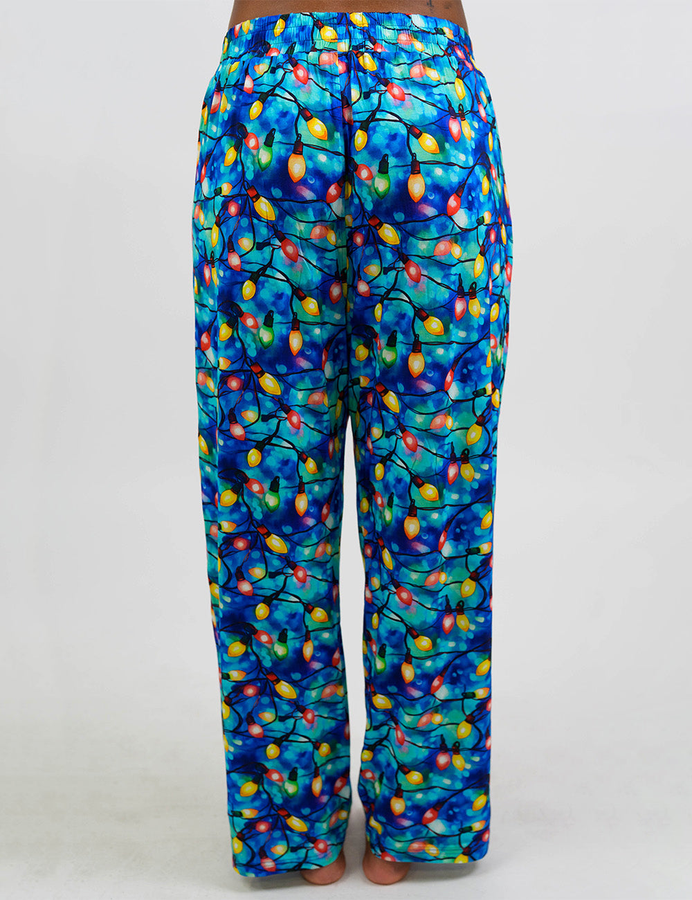 back of the Christmas lights in front of  blue and teal background pajama bottoms against a white background