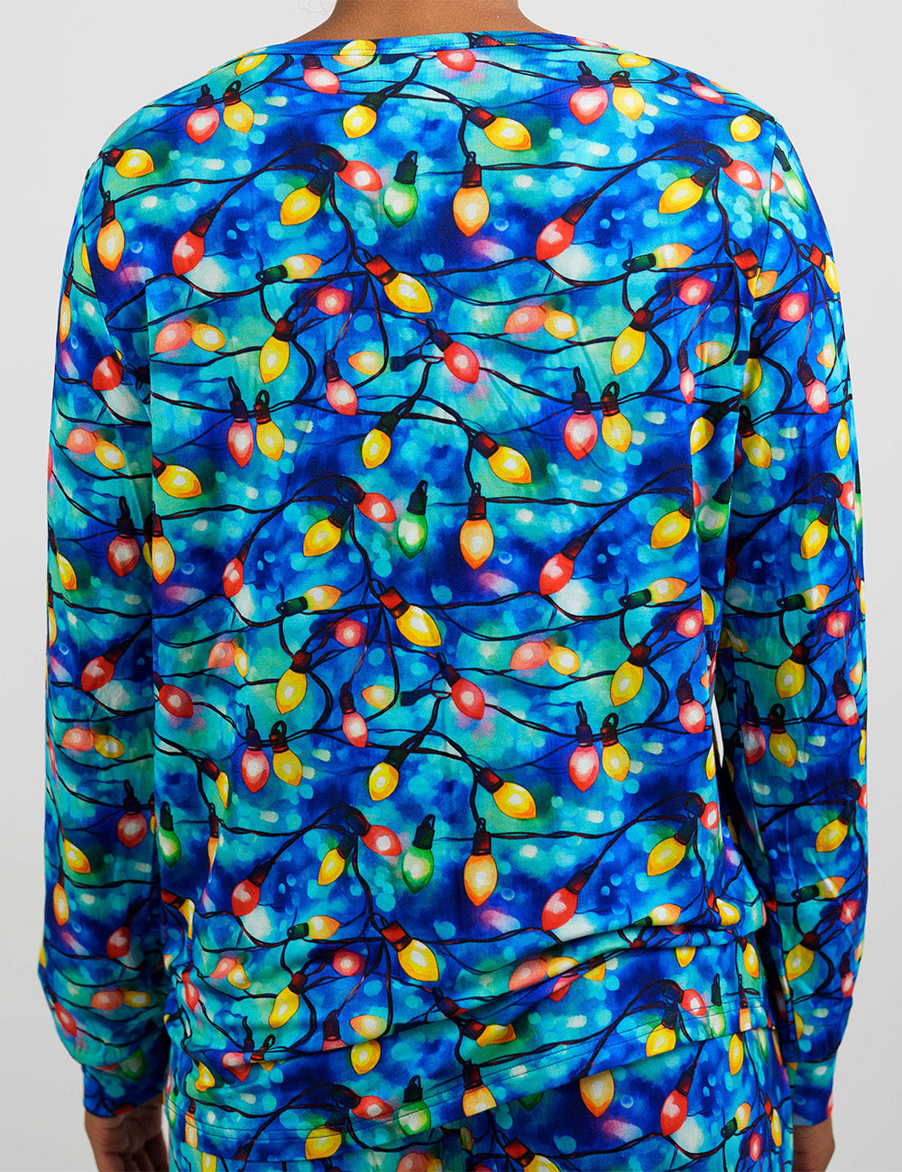 back of the Christmas lights in front of blue and teal background pajama top against a white background
