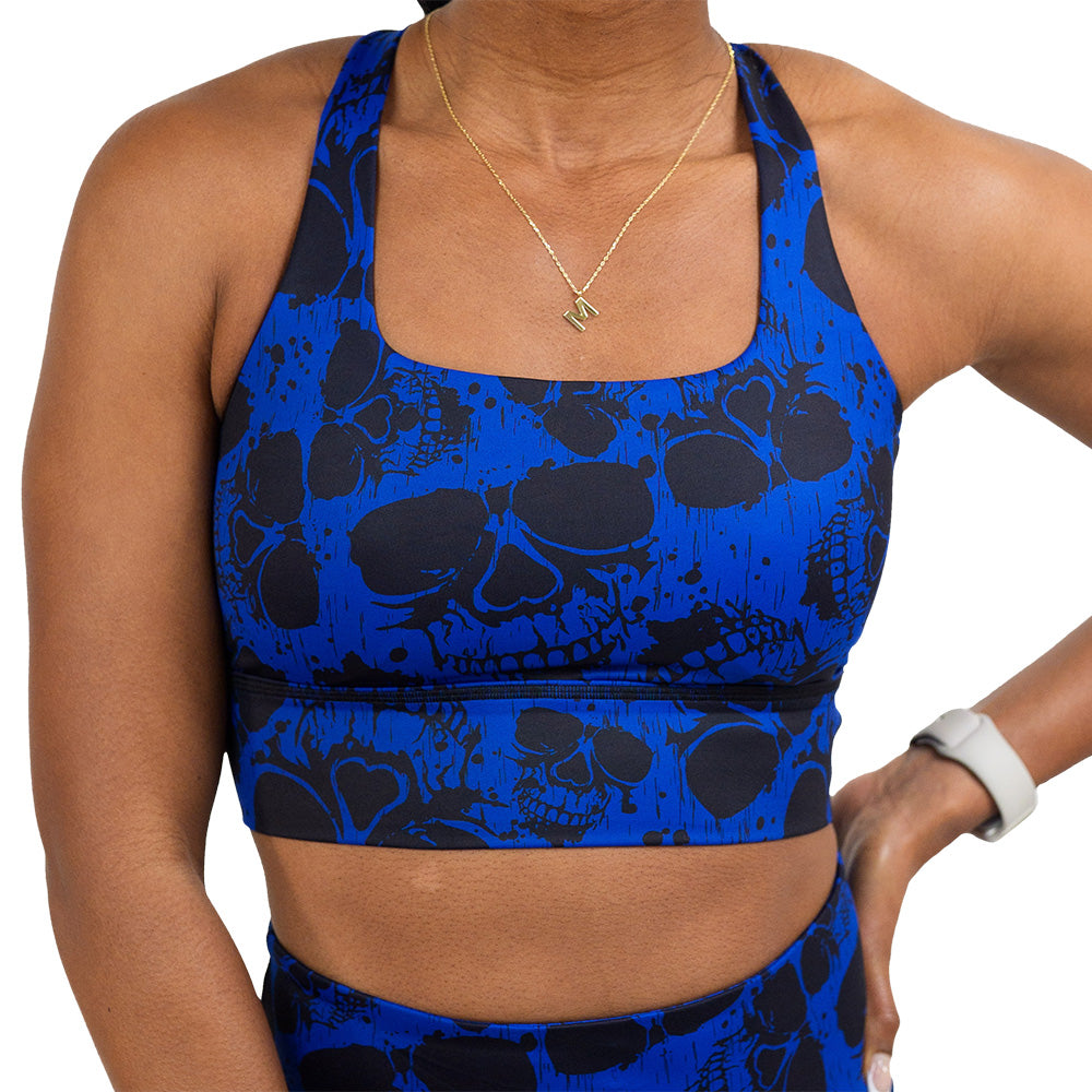 front of the dark skulls against a blue background pattern bra against a white background