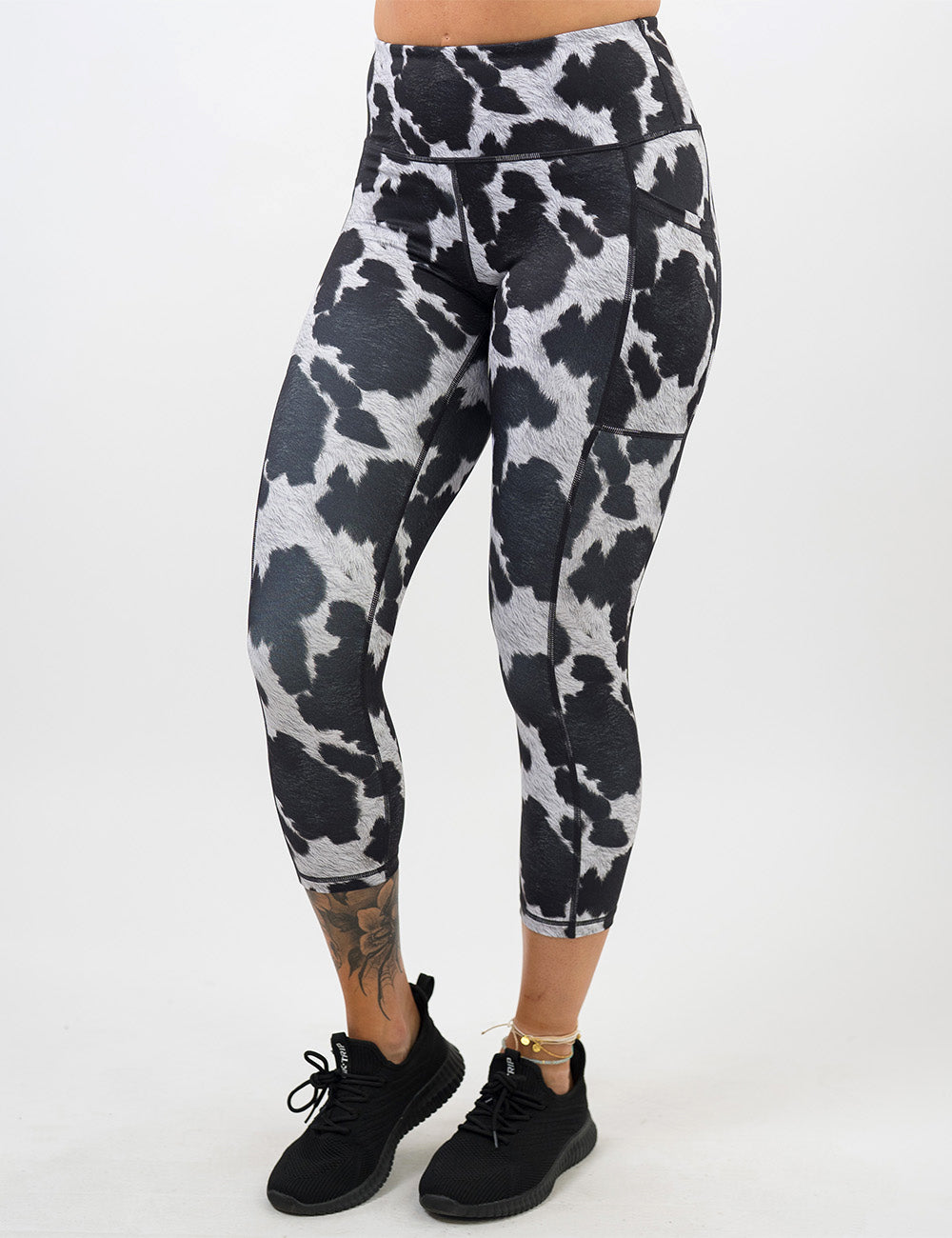 front of the capri cow print leggings against a white background