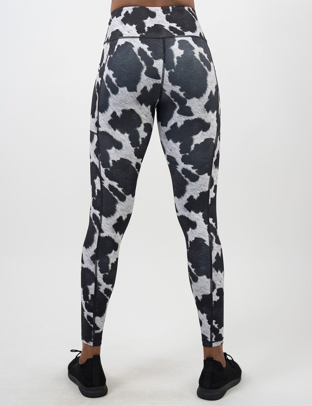 back of the full length cow print leggings against a white background